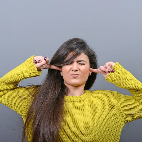 Retrato de mujer cubriendo orejas con las manos contra el fondo gris —  Fotos de Stock