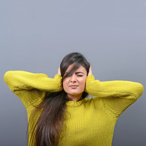 Retrato de mujer cubriendo orejas con las manos contra el fondo gris —  Fotos de Stock