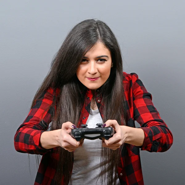 Портрет женщины, играющей в видеоигры на сером фоне — стоковое фото