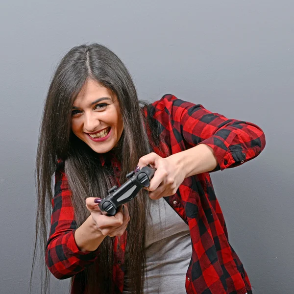 Retrato de mujer jugando videojuegos sobre fondo gris — Foto de Stock