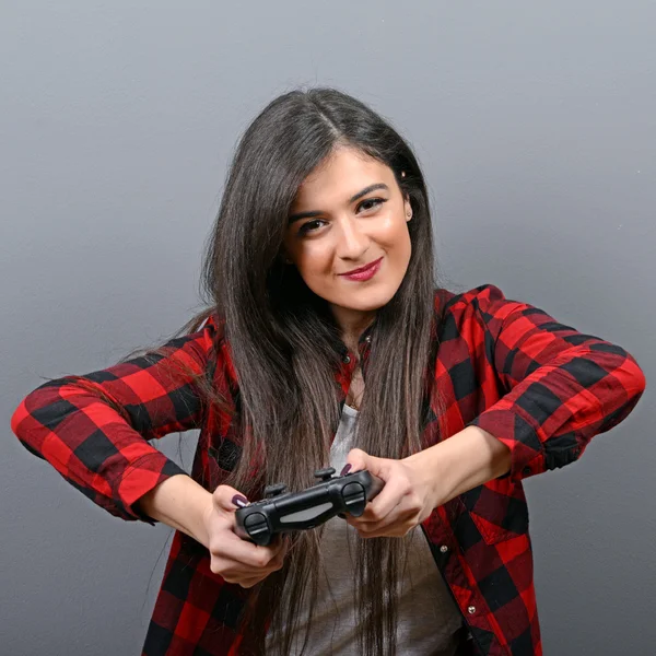 Retrato de mujer jugando videojuegos sobre fondo gris — Foto de Stock