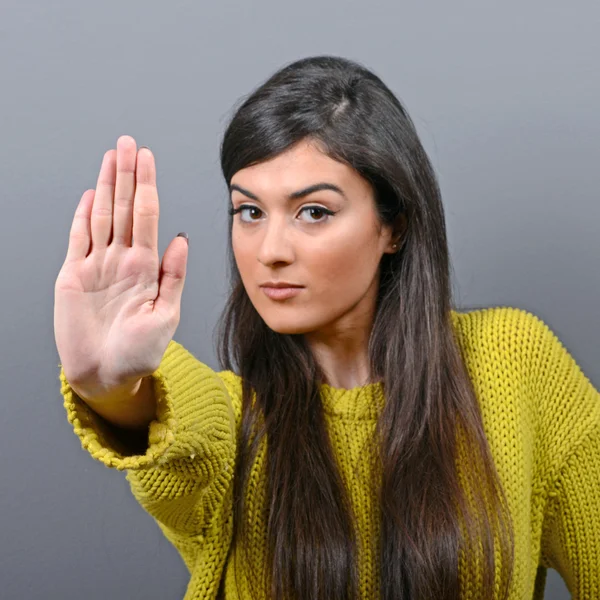 Retrato de mujer mostrando stop con mano sobre fondo gris —  Fotos de Stock