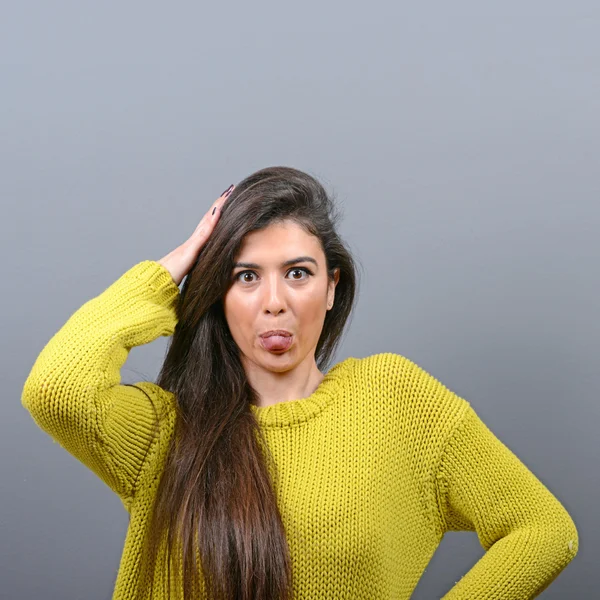 Retrato de mulher saindo de sua língua contra backgroun cinza — Fotografia de Stock