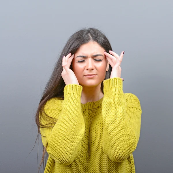 Porträt einer Frau mit Kopfschmerzen vor grauem Hintergrund — Stockfoto
