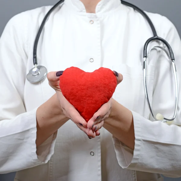 Ritratto di giovane bella donna medico che tiene di nuovo il cuore rosso — Foto Stock