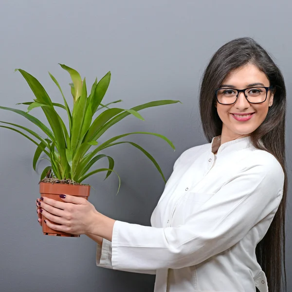 Retrato de una joven botánica en uniforme con planta agains —  Fotos de Stock