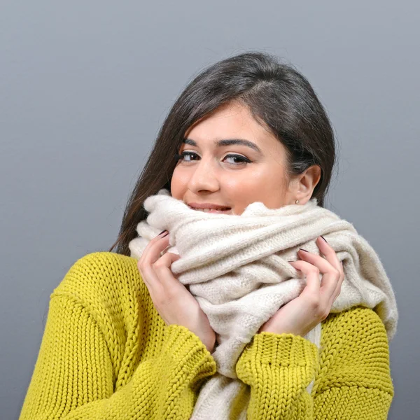 Портрет молодой женщины в зимней одежде против серой спинки — стоковое фото