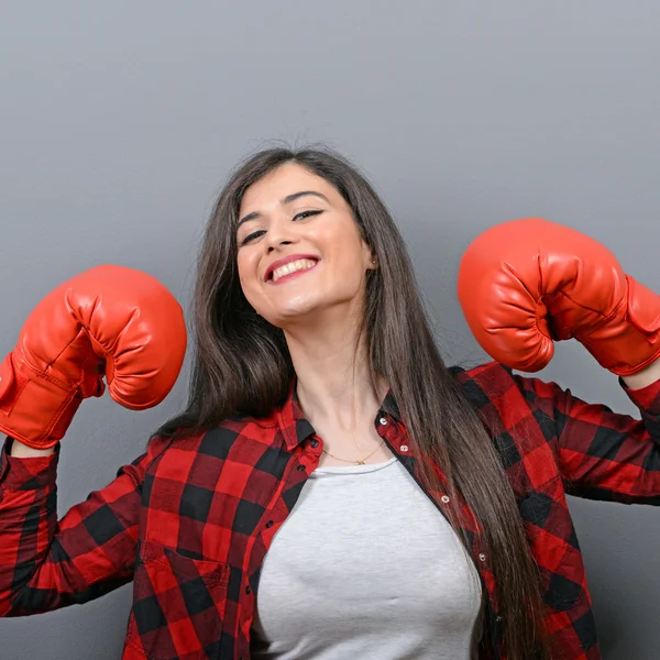 Retrato de mujer joven posando con guantes de boxeo contra gris b — Foto de Stock