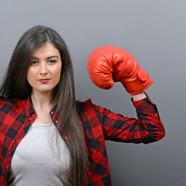 Retrato de mujer joven posando con guantes de boxeo contra gris b — Foto de Stock