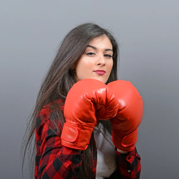 Retrato de mujer joven posando con guantes de boxeo contra gris b — Foto de Stock