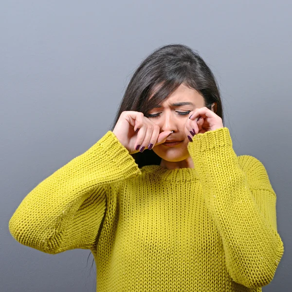 Mujer llorando y limpiando lágrimas sobre fondo gris —  Fotos de Stock