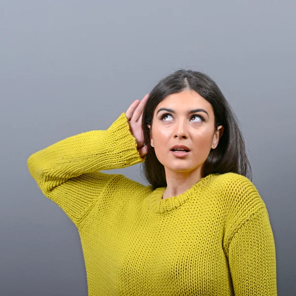 Frau hört mit der Hand auf Ohrenkonzept vor grauem Hintergrund — Stockfoto