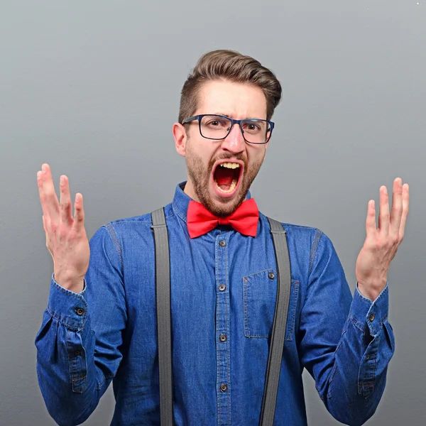 Portrait of a angry man screaming against gray background — Stock Photo, Image