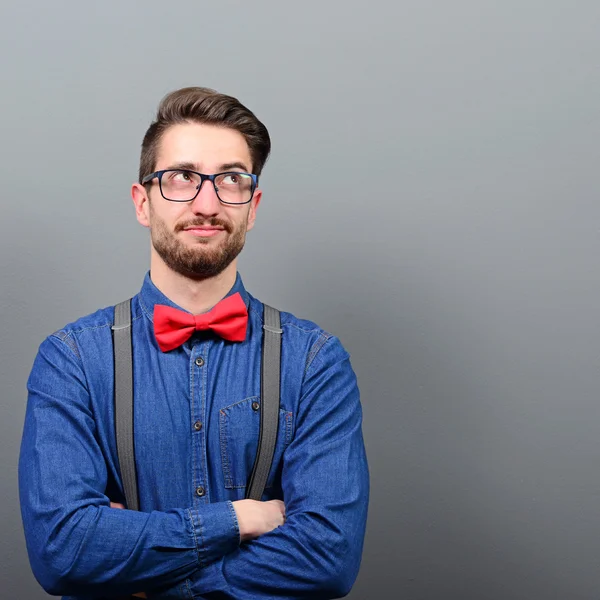 Portrait of a man thinking and looking above against gray backgr — Stock Photo, Image