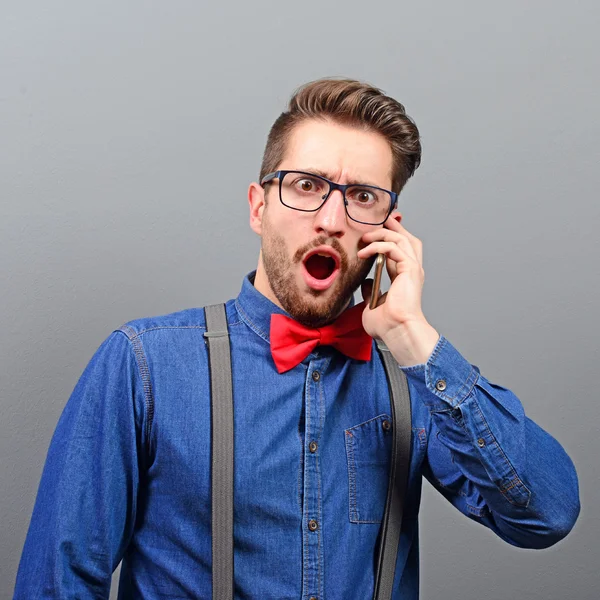 Portrait of amazed or shocked man talking on cellphone against g — Stock Photo, Image