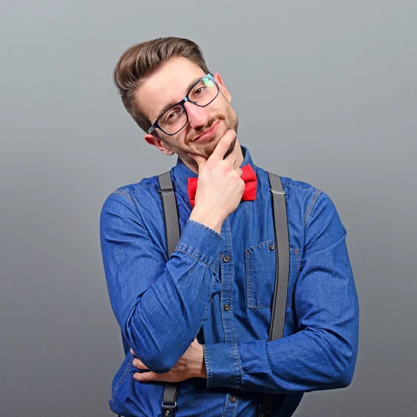 Portrait of attractive young man against gray background — Stock Photo, Image