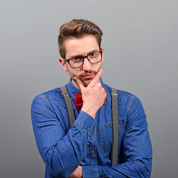 Portrait of attractive young man thinking about something agains — Stock Photo, Image