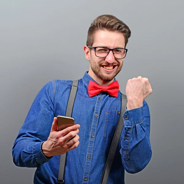 Portrait of ecstatic man holding cell phone and celebrating with — Stock Photo, Image