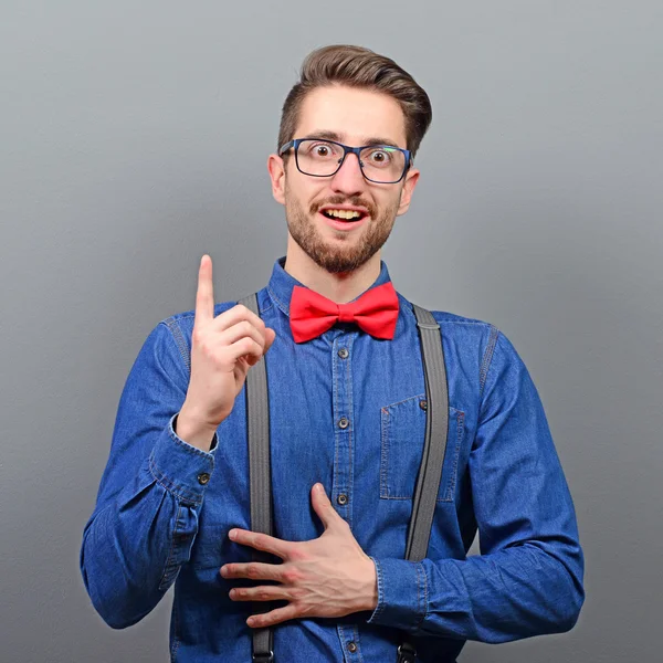 Portrait of man pointing up as a sign of having an idea against — Stock Photo, Image