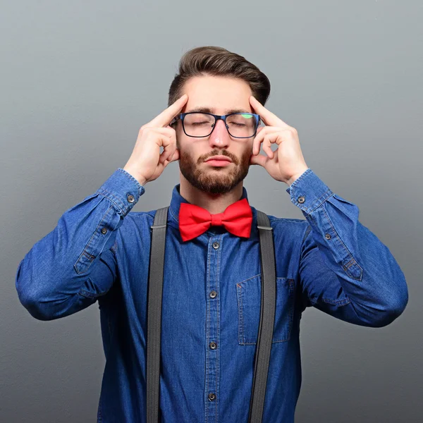 Portrait of young man concentrating against gray background — Stock Photo, Image