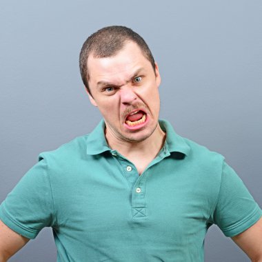 Gri arka plan karşı çılgın görünümlü bir adam portresi