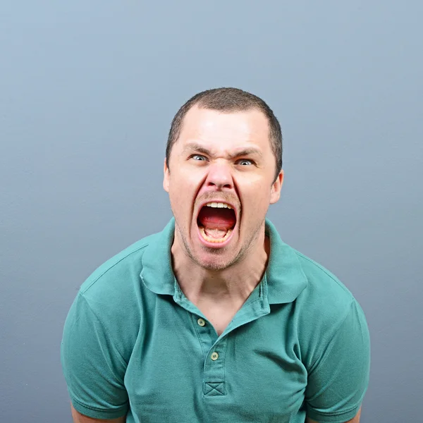 Retrato de um homem com raiva gritando contra fundo cinza — Fotografia de Stock