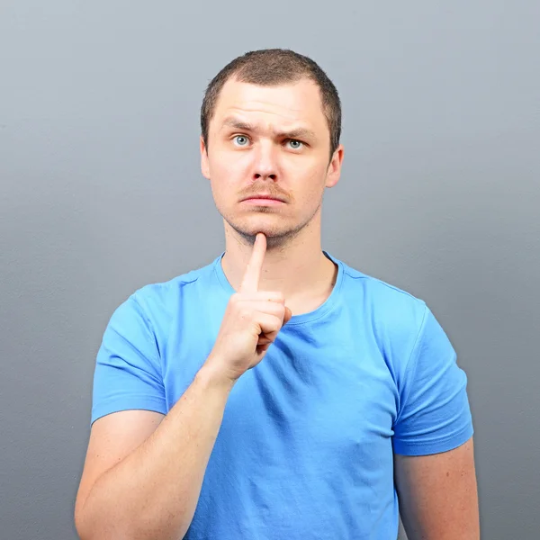 Portrait of attractive young man thinking about something agains — Stock Photo, Image