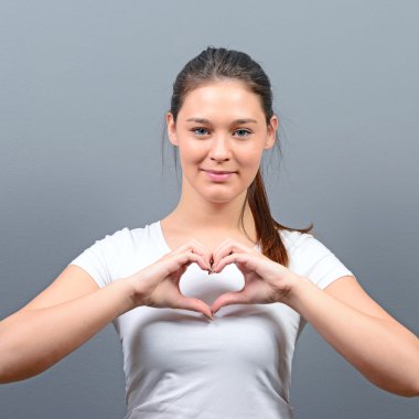 Güzel mutlu kadın kalp gri backg karşı el ile yapma