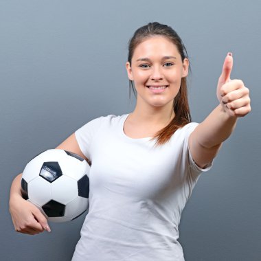 Futbol ile gri bac karşı başparmak tutarak kız portresi