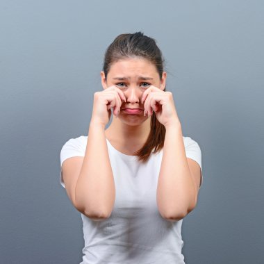 Gri arka planı ağlıyor ve silerek kadın gözyaşları