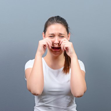 Gri arka planı ağlıyor ve silerek kadın gözyaşları