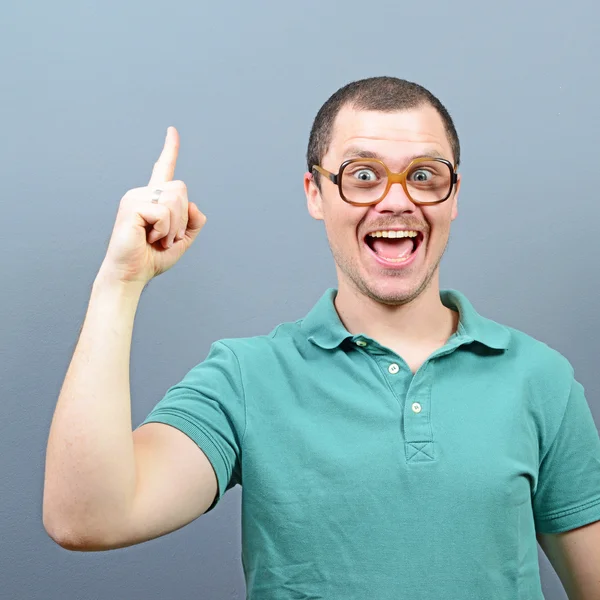 Retrato de tipo nerd divertido teniendo una idea contra el fondo gris —  Fotos de Stock