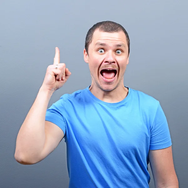 Portrait of man pointing up as a sign of having an idea against — Stock Photo, Image