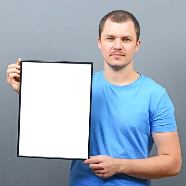 Serous looking man holding empty board - Perfect for raising awa — Stock Photo, Image