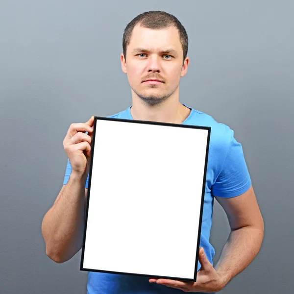 Serous looking man holding empty board - Perfect for raising awa — Stock Photo, Image