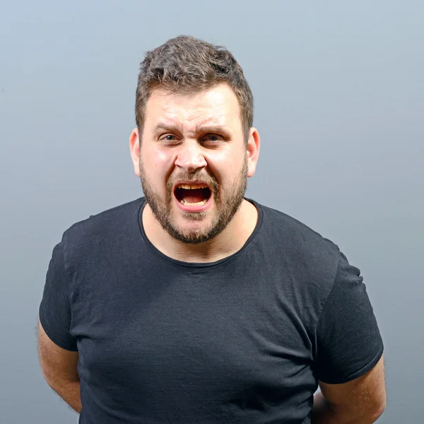 Retrato de un hombre enojado gritando sobre fondo gris — Foto de Stock