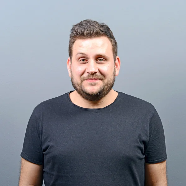 Portrait of chubby young man against gray background — Stock Photo, Image