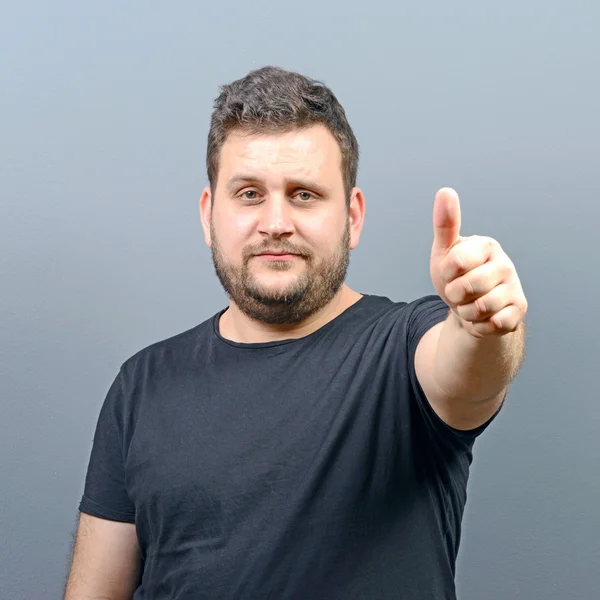胖胖的年轻男人出现的肖像大拇指和灰色的背部 — 图库照片