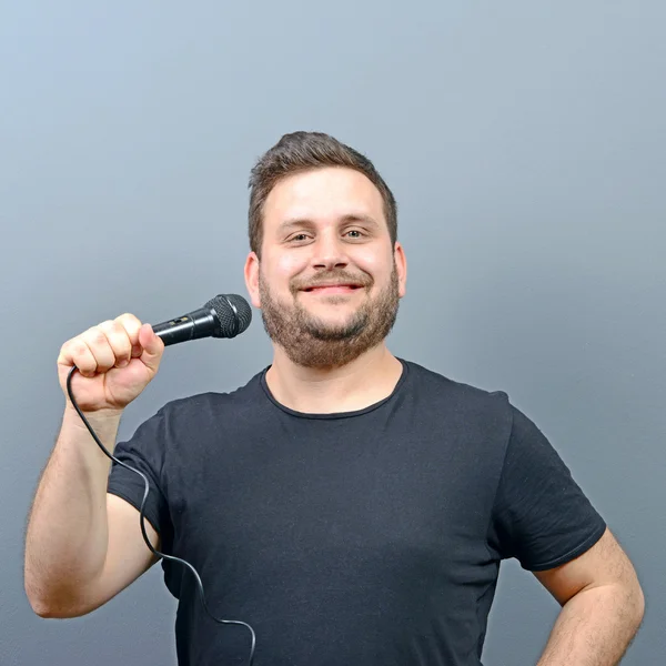 Retrato de engraçado gordinha homem cantor contra fundo cinza — Fotografia de Stock