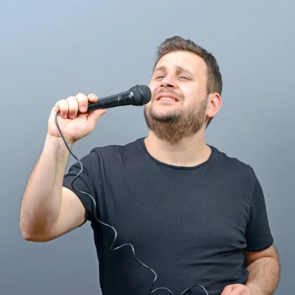 Portrait of funny chubby man singer against gray background — Stock Photo, Image