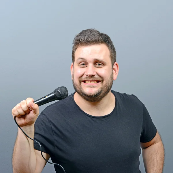 Portret van grappige mollige mens zanger tegen de grijze achtergrond — Stockfoto