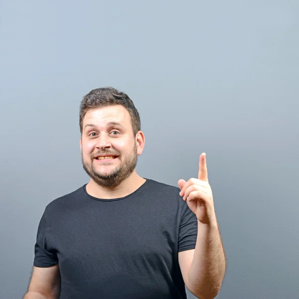 Portrait of man pointing up as a sign of having an idea against — Stock Photo, Image