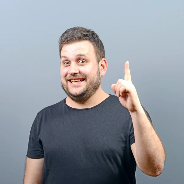 Portrait of man pointing up as a sign of having an idea against — Stock Photo, Image