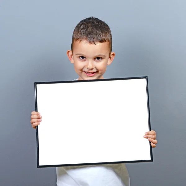 Miúdo bonito segurando placa em branco com espaço para algum texto — Fotografia de Stock