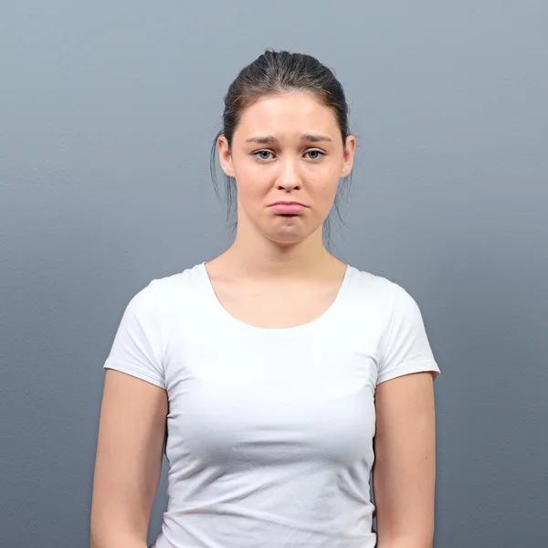 Porträt einer traurigen Frau vor grauem Hintergrund — Stockfoto