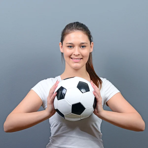 Портрет девушки, держащей футбол на сером фоне — стоковое фото