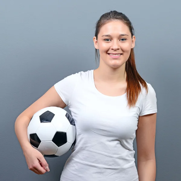 Портрет девушки, держащей футбол на сером фоне — стоковое фото