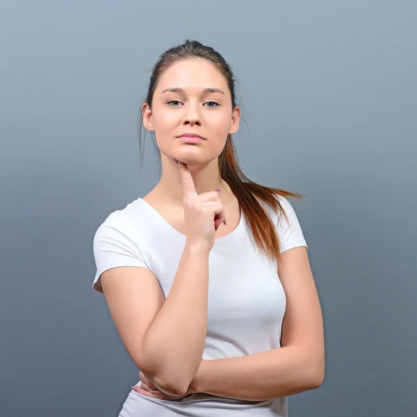 Porträt einer nachdenklichen jungen Frau vor grauem Hintergrund — Stockfoto