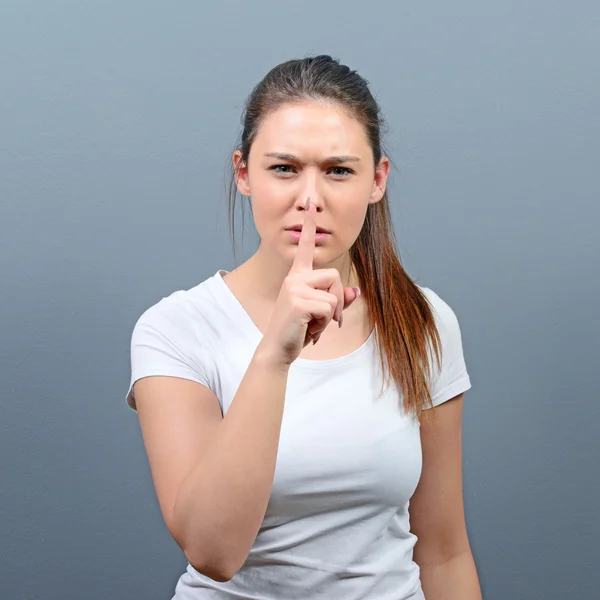 Retrato de mujer sosteniendo el dedo sobre los labios como gesto silencioso aga — Foto de Stock