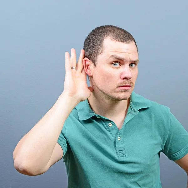 Portrait of handsome man secretly listening on private conversat Stock Image